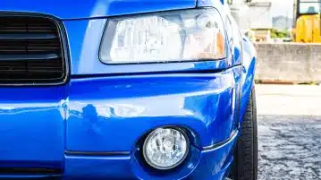 blue car parked on gray concrete road during daytime