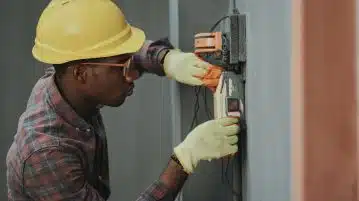 man in brown hat holding black and gray power tool