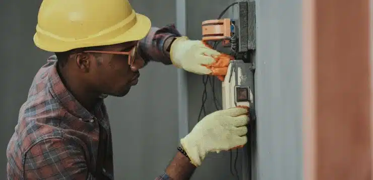 man in brown hat holding black and gray power tool