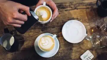 person holding teacup near saucer