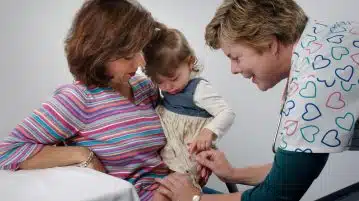 woman carrying toddler sitting on chair