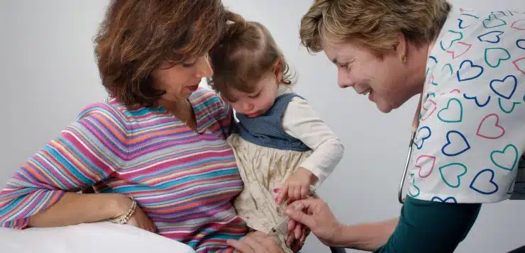 woman carrying toddler sitting on chair