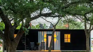 brown wooden house near green tree during daytime